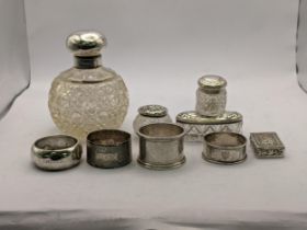 Mixed silver items to include fair napkin rings, one silver bottle, two jars with silver lids and