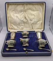 A cased set of four silver salts with glass liners along with four salt spoons and two salt