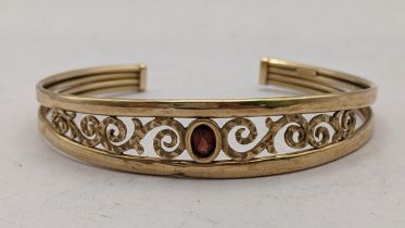 A 9ct pierced bangle having scroll work design and inset with Citrine , 6.1g Location: