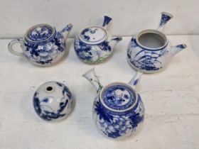 Four early 20th century Japanese teapots and a vase decorated in blue and white A/F Location: