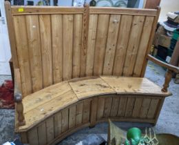 A 19th century pine curved oak and pine settle with a planked back, part hinged seat, on square legs