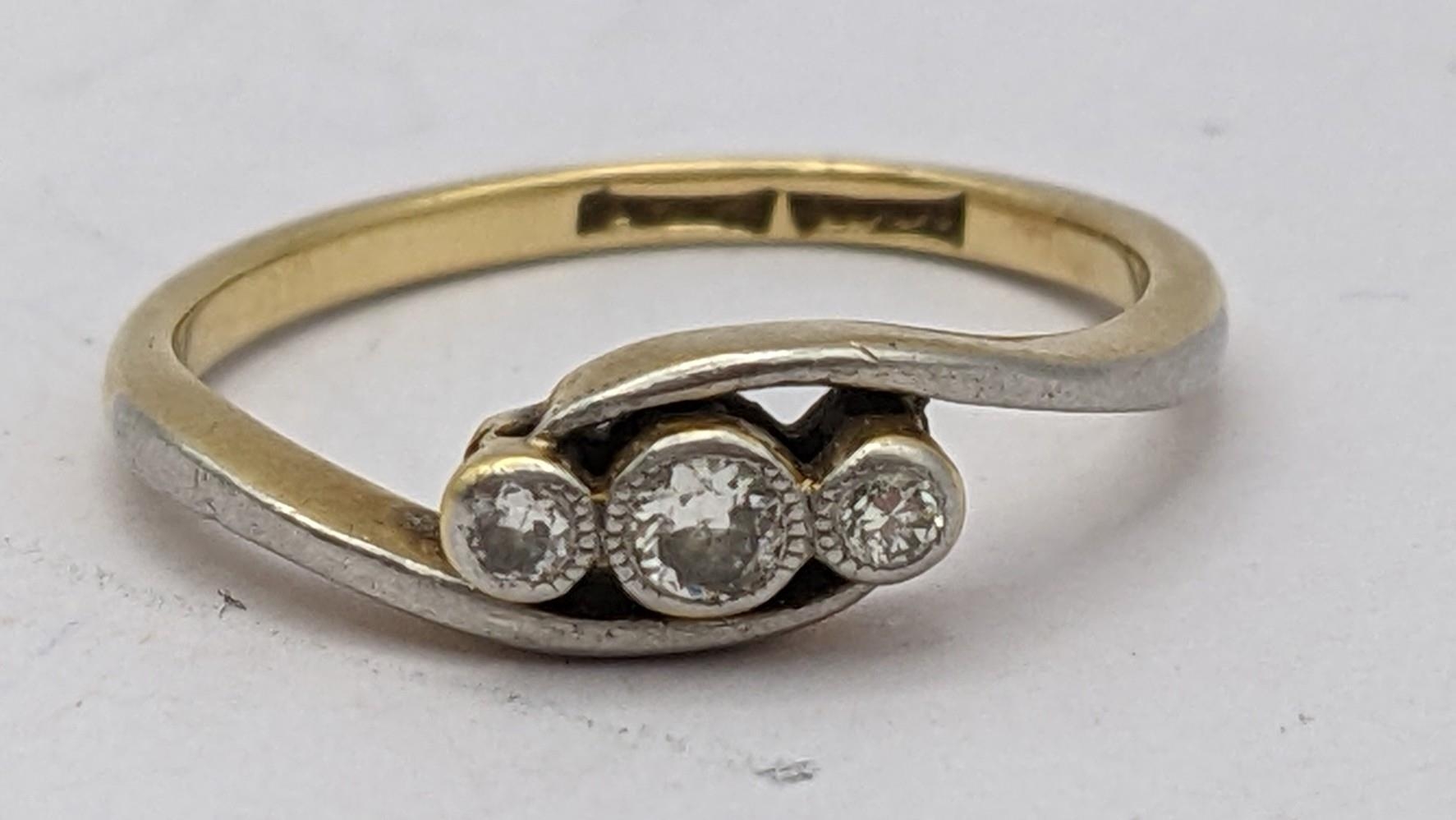 An 18ct gold ring inset with three diamonds 2.1g Location: