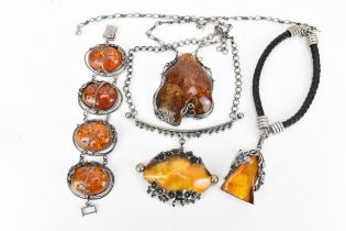 A collection of baltic amber mounted jewellery, each in naturalistic white metal and silver mount,