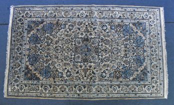 A Persian hand-woven wool and silk Nain rug, with cream ground and floral palmettes and meandering