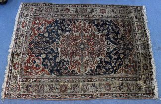 A handwoven Persian silk rug, designed with central medallion on iron red ground, against a dark