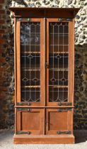 An early 20th century Arts and Crafts oak vitrine cabinet, with stained lead glass and brass