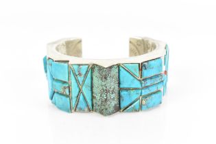 A Native American Navajo silver cuff bracelet, set with turquoise and coral, designed with