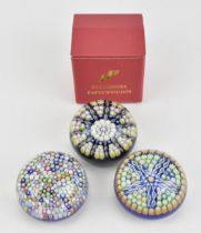 Three Perthshire millefiori cane glass paperweights, each of domed form, two with central cane