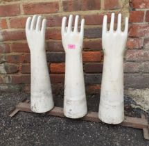 A set of three vintage ceramic latex glove moulds, on a metal stand produced by AHG