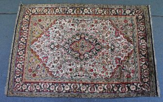 An Indian hand-woven kashmir silk rug, the cream ground with central floral medallion, surrounded