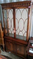 A reproduction mahogany display cabinet having a dental moulded cornice above two glazed and two