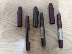 A group of three early 20th century Bakelite cased dip pens with glass nibs, each with Spanish