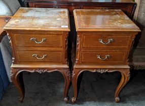 A pair of reproduction French bedside tables having two drawers, floral carved decoration and on