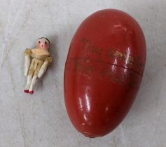 A 19th century peg jointed wooden doll with egg shaped case inscribed ' The Smallest Doll in the