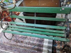 A green painted and wrought iron slatted garden bench 150cms Location: