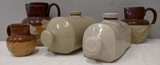 Three Doulton Lambeth jugs of various sizes and a pair on stone bed warmers Location: