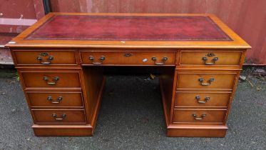 A reproduction mahogany twin pedestal desk having a red leather top above nine drawers 79cm h x