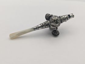 A late 19th/early 20th century white metal baby rattle whistle having a Mother of Pearl handle