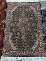 A contemporary Persian style machine woven rug, floral pattern with border surrounding a central