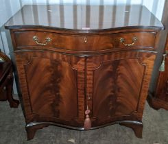 A reproduction mahogany serpentine fronted cabinet having a single drawer above two cupboard