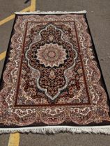 A modern Persian style machine woven Elena rug, ornate design on a black ground, double guard border