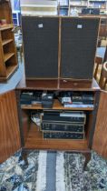 A vintage mahogany music cabinet containing a Sony music system and mixed cassettes Location: