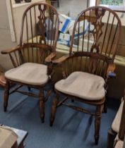 A pair of reproduction Windsor armchair having spindle and pierced splat back support and on