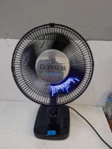 A Guinness advertising table top fan with illuminated blades spelling 'Just that little bit