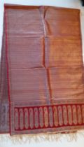 An Indian machine made metallic thread shawl having a red ground with a boteh border and gold