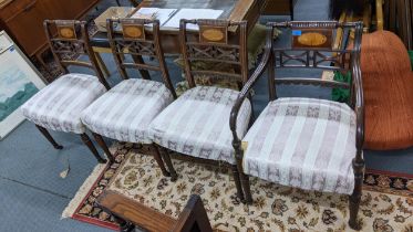 A set of four Regency mahogany dinning chairs with inlaid table backs on turned legs and casters