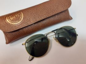 Ray Ban-A pair of vintage brushed gold tone sunglasses with circular green lenses, model no; WO967