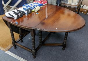 An early 20th century oak gateleg table having bobbin turned supports and two fall flaps, 73cm h x