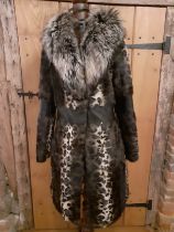 Marccain- An animal print ladies coat having a wolf fur collar and zig-zag black leather waistband