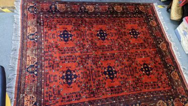 A Persian hand woven rug having a floral design on a red ground and multi-guard borders, 162cm x