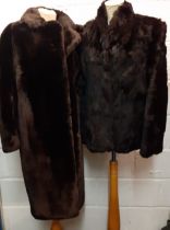 A vintage brown beaver lamb knee-length coat, 40" chest x 39" long together with a vintage black