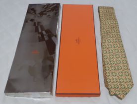 Hermes- A silk tie in yellow having brown and green images of melons and melon segments in an iconic