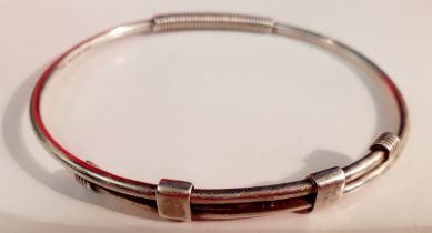 Gucci- A silver adjustable bangle stamped with the designer's name, 17.59g. Location:Rail