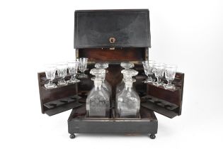 A late 19th century Victorian ebonised and brass inlaid cave a liqueur, the tantalus enclosing a set