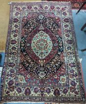 A Persian hand woven red ground rug having central motif, floral multi-guard border, 144cm x 200cm