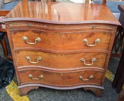 A Georgian inspired mahogany serpentine fronted chest of three drawers having a brush slide and