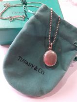 Tiffany-A silver necklace having a ball chain and a small oval shaped locket with makers mark