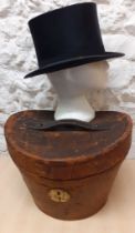 A Victorian brown leather top hat box with fitted red silk interior having a Continental travel