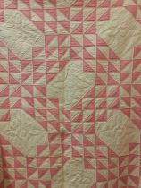 A 1970's American Mid West handmade double layer patchwork quilt in pink, white and cream having a