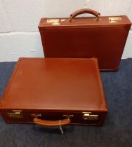 Two chestnut brown leather briefcases having gold tone hardware. Location:1.2 Condition: Good,