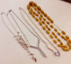 Four vintage necklaces to include simulated pearls and a white tone and white paste stone