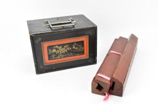 A Mah-Jong set within a black, and red lacquer box decorated with gilt chinoiserie, the slide
