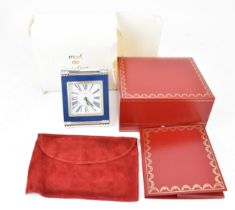 A Cartier travel alarm clock in a rectangular strut frame with turned and ribbed chrome supports,