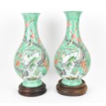 A pair of 20th century Chinese enamelled baluster vases, each covered in a green enamel ground