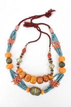 Two Moroccan Berber style pressed amber, white metal, and coral necklaces, one with turquoise beads,