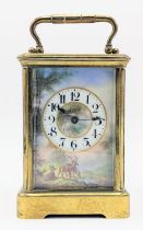 An early 20th century brass cased carriage clock, having a painted dial depicting deer drinking by a